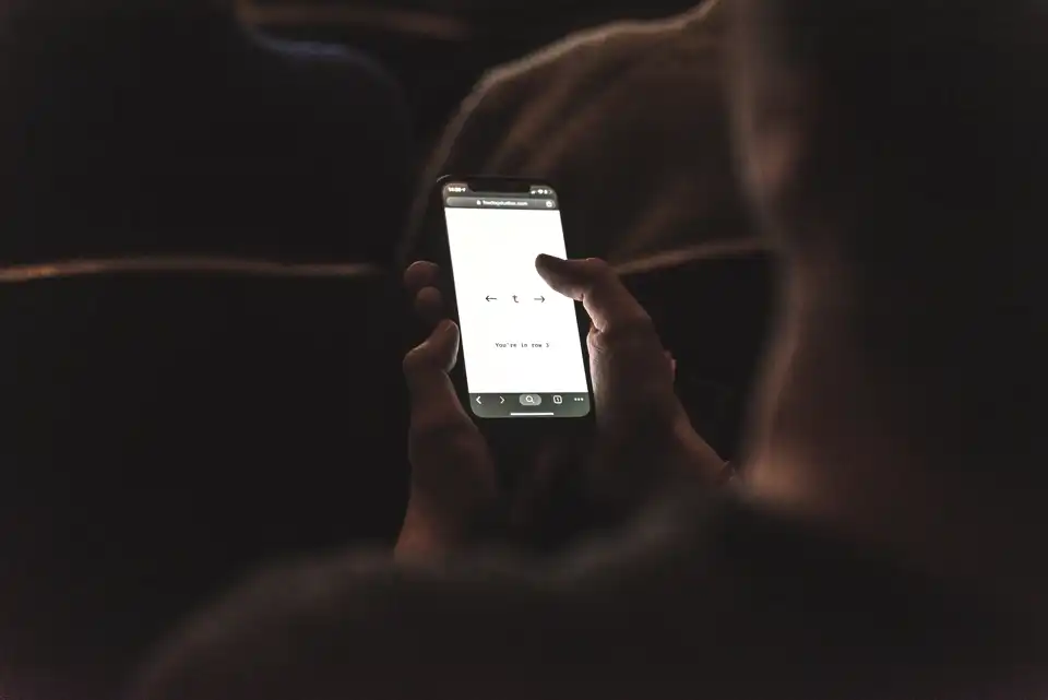 An audience member playing Zeros, moving their character with their phone.